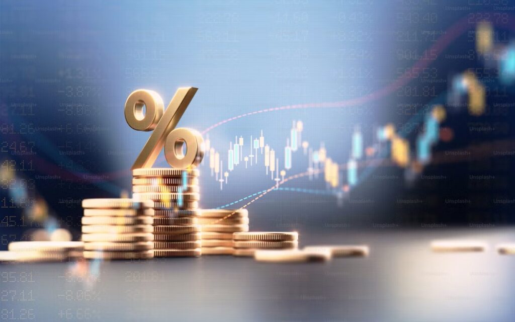 Symbole de pourcentage sur des pièces de monnaie devant un graphique financier illustrant le taux directeur de la Banque du Canada.